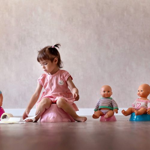 Beautiful,Smiling,Little,Baby,Sitting,On,Potty.,Cute,Adorable,Funny Beautiful smiling little baby sitting on potty. Cute adorable funny child girl using chamber pot together with her baby doll. Toilet training concept. Toddler learning to use the Toilet.